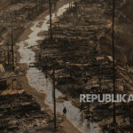 Seorang pria berjalan di tengah kehancuran yang disebabkan kebakaran di kawasan Pacific Palisades, Los Angeles, Kamis, 9 Januari 2025.